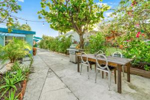 a wooden table and chairs in a garden at Salthaus West Palm Beach - NEW Saltwater Pool & Spa! in West Palm Beach