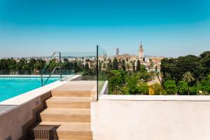 uma escada que leva a uma piscina com vista para a cidade em Hotel Alcázar em Sevilha