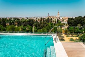 a swimming pool with a view of a city at Hotel Alcázar in Seville