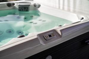 a bath tub with a sink in a bathroom at Somos Lux Vendégház in Somoskőújfalu +105 photos