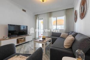 ein Wohnzimmer mit einem Sofa und einem TV in der Unterkunft Pass the Keys Apt family friendly in Marbella