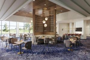 a restaurant with tables and chairs in a room with windows at Delta Hotels by Marriott Toledo in Toledo