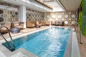 basen w hotelu z krzesłami i patio w obiekcie Catalonia Giralda w Sewilli