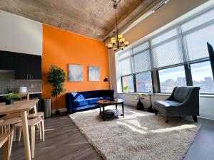 een woonkamer met oranje muren en een tafel en stoelen bij McCormick 2Br/2Ba family unit for up to 6 guests with Optional Parking & Gym access in Chicago