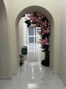 Un arco con flores rosas en un pasillo. en Royal Dream, en Nápoles