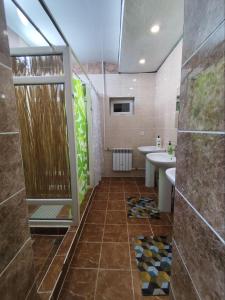 ein Bad mit einer Dusche und einem Waschbecken in der Unterkunft Urban Monkey Tent hostel & bar in Karakol