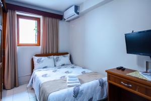 niewielka sypialnia z łóżkiem i telewizorem w obiekcie Homelike Guest House w mieście Kirenia