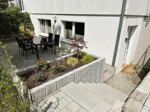 a patio with a table and chairs and a garden at Rottweiler Ferienwohnung in Rottweil