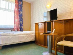 a bedroom with a bed and a tv and a table at Motel Petro in Torzym
