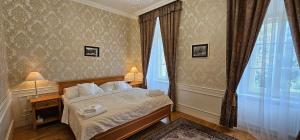 Zamecky Hotel Lednice في ليدنيس: غرفة نوم عليها سرير وفوط