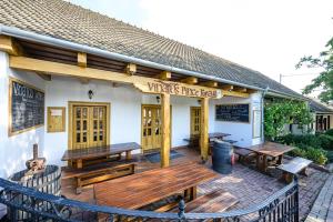 ein Gebäude mit Bänken und Tischen auf einer Terrasse in der Unterkunft Vinatus Pince in Villány