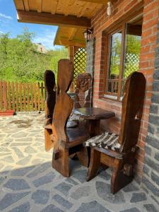 een houten tafel en stoelen op een patio bij Hanu lu’ Vasile in Breb