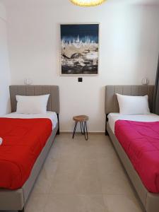 two beds sitting next to each other in a room at Kipos Villas & Suites in Mýkonos City