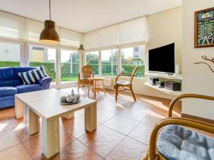 a living room with a blue couch and a table at Luxurious Holiday Home in Koudum with Pool in Koudum