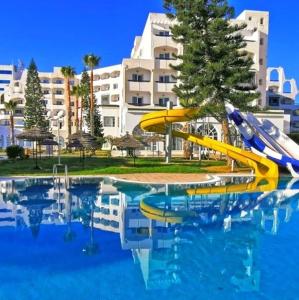 uma piscina com escorrega em frente a um edifício em Hotel Jinene Resort em Sousse