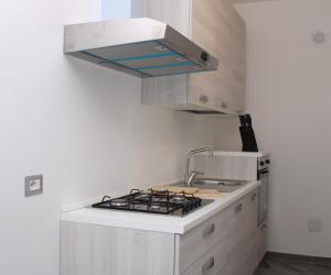 a kitchen with a sink and a stove top oven at JOHN'S ROOMS in Villa D'agri