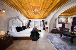 a large black dog standing in a bedroom with a bed at Cappadocia Pegasos Cave Suite Hotel in Uchisar +102 photos