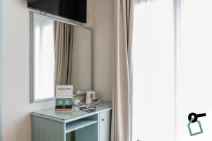 a room with a mirror and a table with a microwave at HOTIDAY Hotel Jesolo Lido in Lido di Jesolo