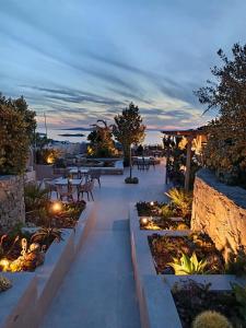 a patio with tables and lights at dusk at Kipos Villas & Suites in Mýkonos City