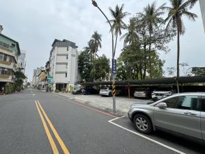 台南的住宿－Triple One Entire Home 慶東111私人招待所 包棟民宿，棕榈树环绕的街道旁的停车场