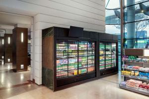 un corridoio del supermercato con frigoriferi e bevande di NH Vienna Airport Conference Center a Schwechat