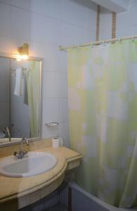 a bathroom with a sink and a shower curtain at New Siesta Hotel & Resort in Alexandria