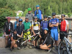 a group of people posing for a picture with their bikes at Hotel Paganella, Tradition In Hospitality in Fai della Paganella