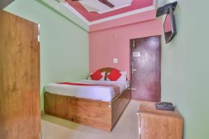 OYO Hotel Happy Journey في Dīgha: غرفة نوم بسرير وباب خشبي