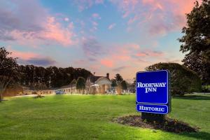 a blue sign in the middle of a field at Rodeway Inn Williamsburg Edge District in Williamsburg