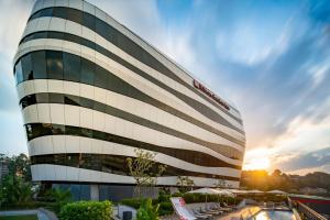 un grand bâtiment avec un coucher de soleil en arrière-plan dans l'établissement Hilton Garden Inn Mbabane, à Mbabane