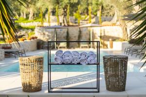 uma prateleira de rolos de papel higiénico ao lado de uma piscina em MASHTRA - The Olive House em Ulcinj