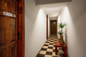 a hallway with a checkered floor and a door at Homelike Guest House in Kyrenia