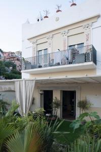 a white house with a balcony and plants at Allegra Experience in Taormina