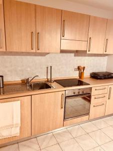 a kitchen with wooden cabinets and a sink at VILLA MONTESOLE in Lecco