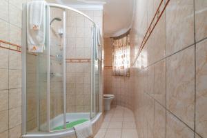 a bathroom with a shower and a toilet at A'lure Hotel & Residences in Kampala