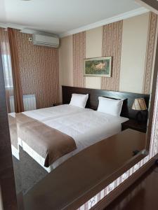 una camera con un grande letto di Хотел-ресторант Алмонд a Karlovo