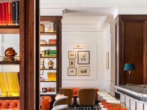 Cape Grace, A Fairmont Managed Hotel في كيب تاون: غرفة معيشة مع كراسي برتقالية وأرفف كتب