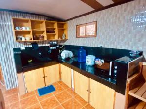 cocina con encimera negra y microondas en Baguio mountain villa view RW en Baguio