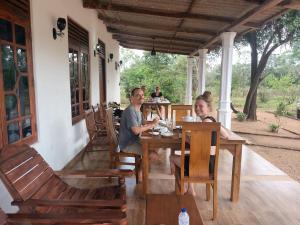 Ein Mann und eine Frau sitzen an einem Tisch in einem Restaurant in der Unterkunft Sigiri Arana in Sigiriya