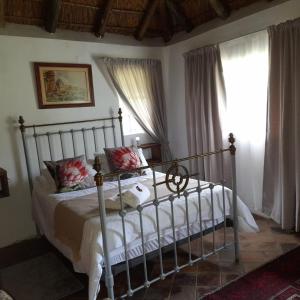 a bedroom with a bed in a room with windows at Marico Guest Lodge in Groot-Marico