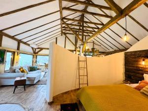 a bedroom with a bed and a ladder in a room at Inside, The Village- The Hut Studio in Tunari