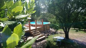 a large deck with a swimming pool in a yard at Gîte La Boutardière in Saint-Aubin-le-Cloud