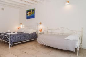 2 Betten in einem Schlafzimmer mit weißen Wänden in der Unterkunft Boutique Hotel Molo S Lucia in Syrakus