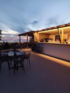 un patio con tavoli e sedie sul tetto di Kipos Villas & Suites a Mykonos Città