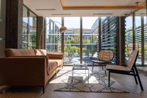 a living room with a couch and chairs and windows at Zenitude Hotel la Valadiere, Ascend Hotel Collection in Montpellier
