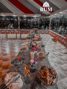 une longue table avec des assiettes de nourriture dans l'établissement Rum desert magic, à Wadi Rum