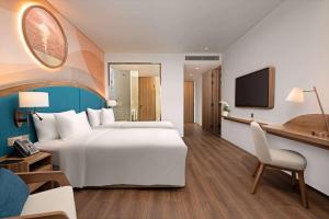 um quarto de hotel com uma cama grande e uma secretária em Wyndham Garden Sonasea Van Don em Ha Long