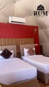two beds in a room with a tent at Rum desert magic in Wadi Rum