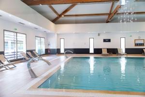 una piscina in una palestra con sedie intorno di Zenitude Hotel la Valadiere, Ascend Hotel Collection a Montpellier