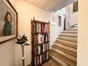 una estantería llena de libros junto a una escalera en Residenza del Gallo - Residenze Tonnina Group, en Casale Marittimo